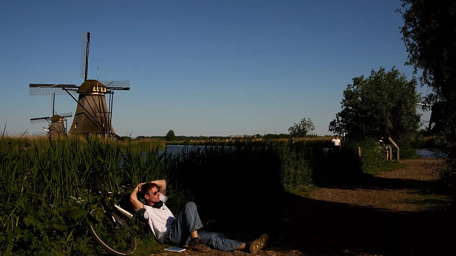 A person rests in the shade near 18th-century windmills. Photo by Lindsay Wasson