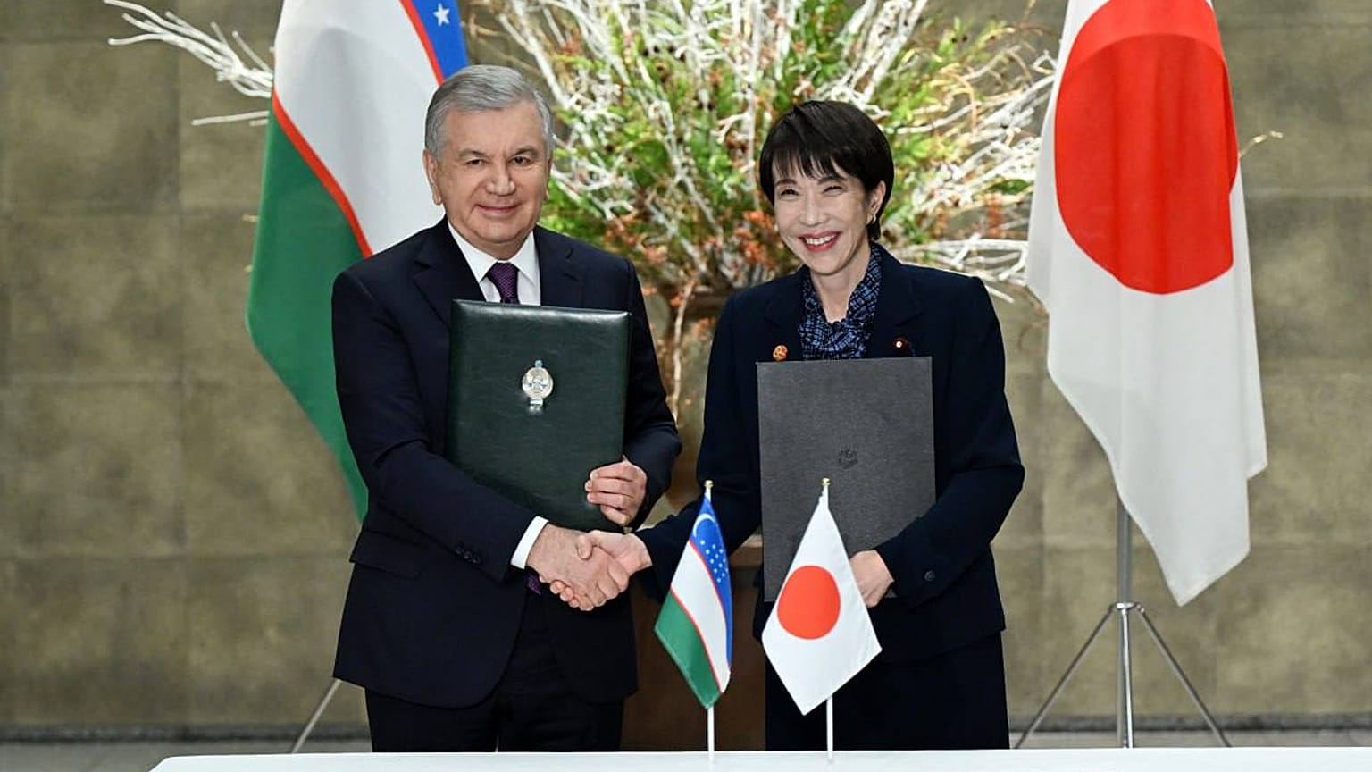 President of Uzbekistan Shavkat Mirziyoyev and Japan’s Prime Minister Sanae Takaichi exchange signed documents following talks in Tokyo