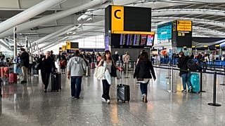 Passengers walk past the departures board at Heathrow Airport, in London, 28 August 2023.