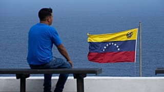 A man looks out at the sea in the city of La Guaira, Venezuela, where the nation's flag flies, Wednesday, Dec. 17, 2025. 