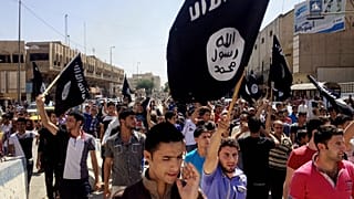 Demonstrators chant pro-Islamic State slogans as they carry the group's flags in front of the provincial government headquarters in Mosul.