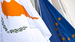 The Cypriot and European flags are seen at the Cypriot delegation building in Brussels on Sunday, 24 March 2013