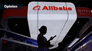 FILE: A visitor walks in front of Alibaba booth during the 3rd China International Supply Chain Expo at the China International Exhibition Center, in Beijing, China, 18 July 2
