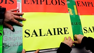 Civil servants stick placards reading "Jobs", top, and "Salary" during a protest over pay in Lille, northern France. 2 Feb. 2006.