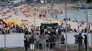 Security gathers at a gate at Bondi Beach in Sydney ahead of a ceremony to mark National Day of Reflection for victims and survivors from the Bondi shooting, Dec. 21, 2025.