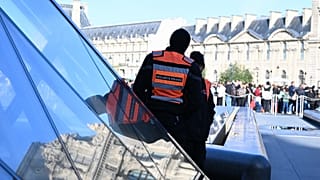 FILE: Private security members watch people queueing outside the Louvre museum, Paris, 30 October 2025