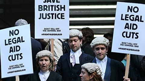 British lawyers protest outside Southwark Crown Court as they demonstrate against British government cuts to legal aid, in London 2014.